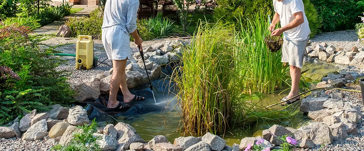 two men fixing a pond