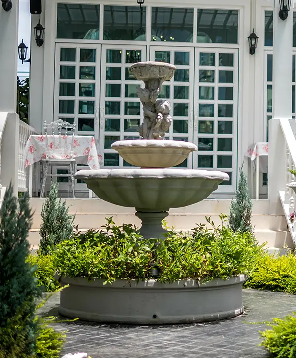 A fountain building in Pensacola, FL, with plants and flowers
